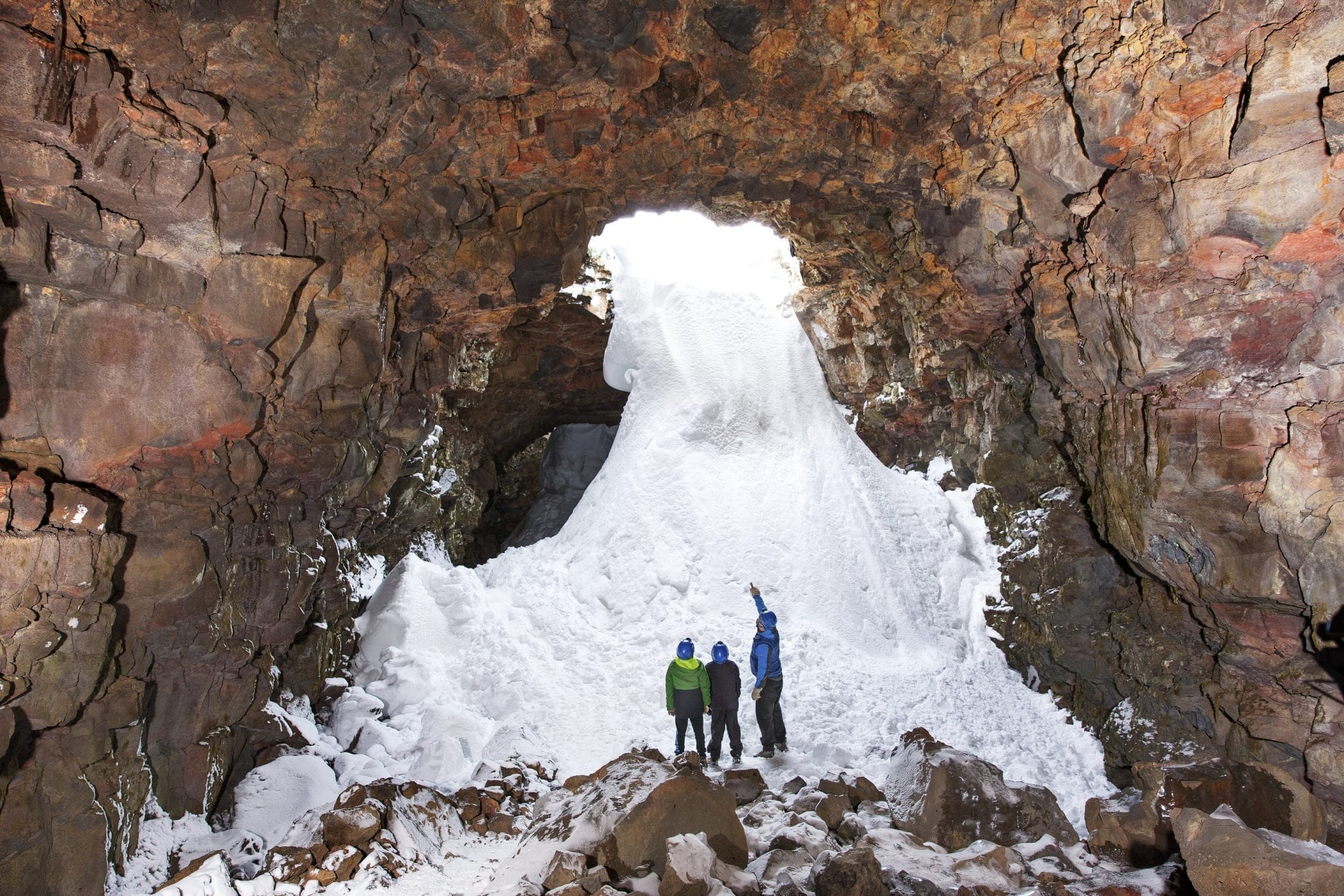 people looking at snow in RAUFARHÓLSHELLIR LAVA TUNNEL