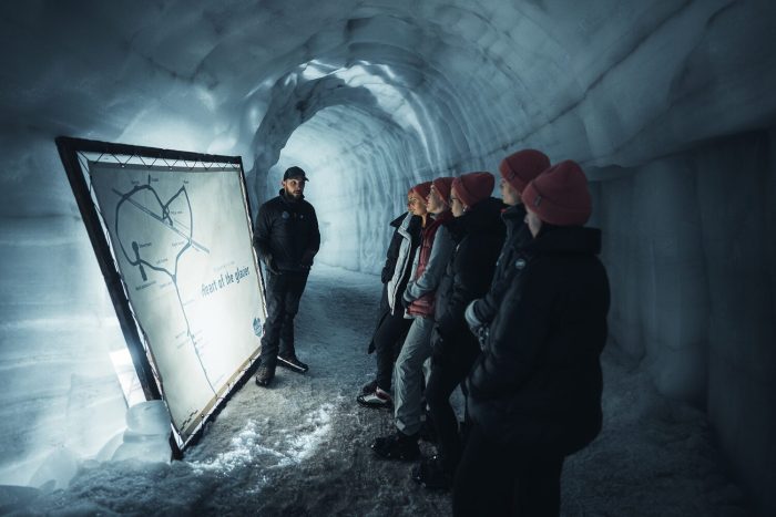 a group of people looking at a map of an ice tunnel