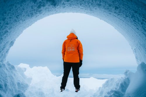 Person standing at entrance of ice tunnel admiring views
