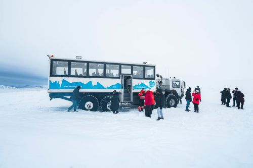 Tour group standing by glacier monster truck