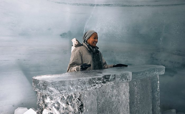 a woman standing behing an ice table