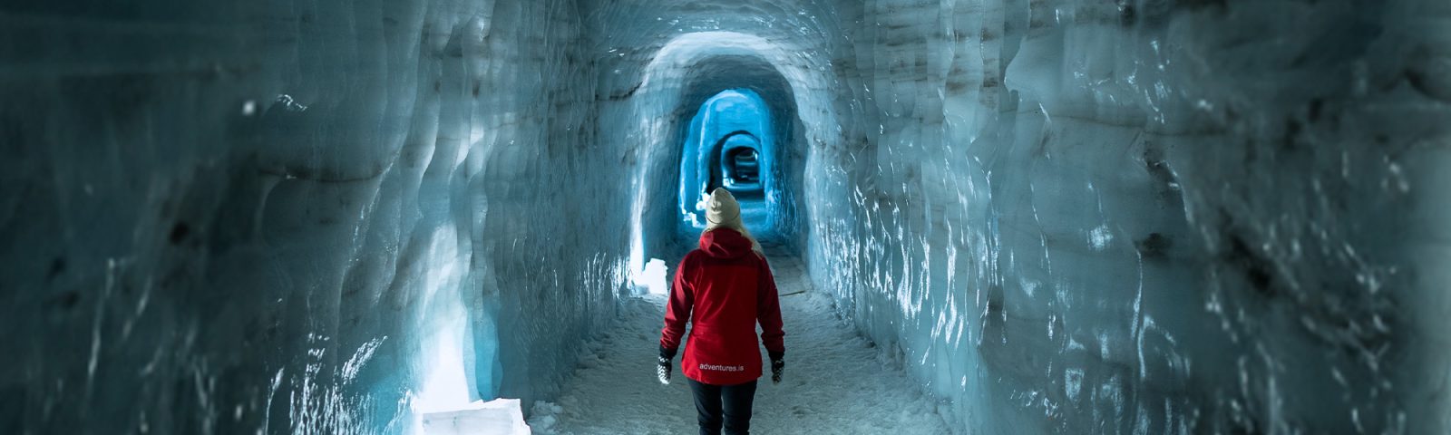 a woman in a red coat in an ice tunnel close up