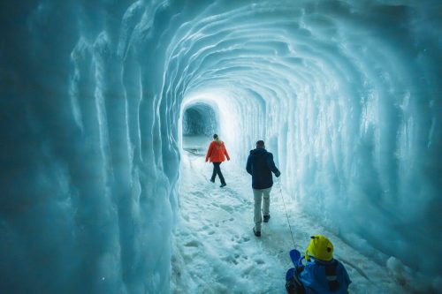Family exploring into the glacier tunnel at Langjokull in Iceland.